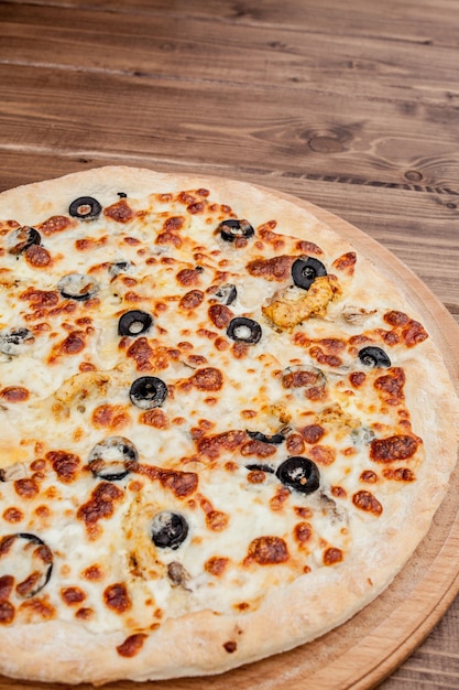Pizza con queso mozzarella, pollo, aceitunas, especias. Pizza italiana