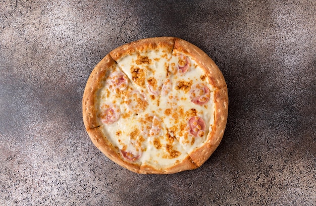 Pizza con queso sobre un fondo oscuro. Copie el espacio.