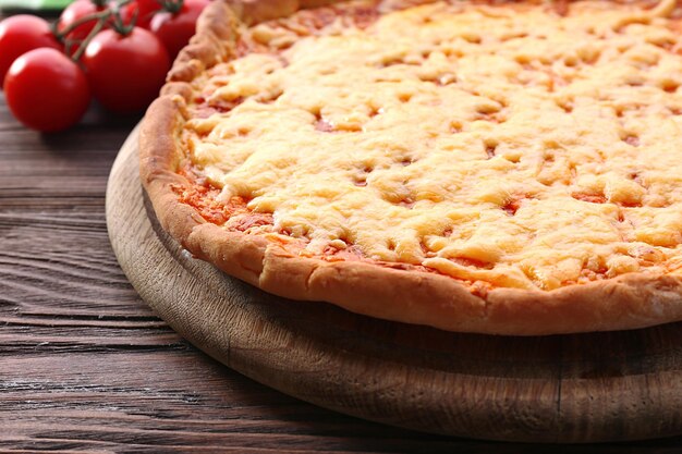 Pizza de queso con tomates cherry en la mesa de cerca