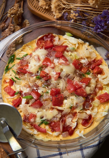 Una pizza con queso y tomates encima.