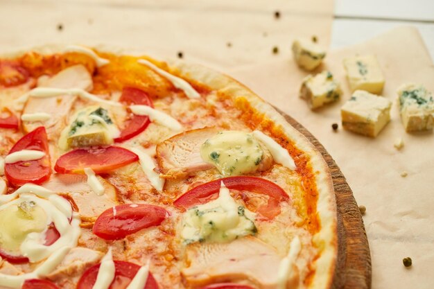 Pizza recién horneada con filete de pollo ahumado y queso gorgonzola servido sobre fondo de madera con salsa de tomate y hierbas Concepto de entrega de alimentos Menú del restaurante