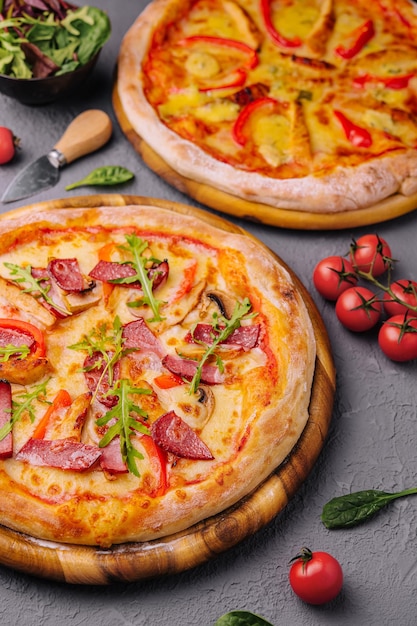 Pizza redonda al horno hecha con tomates salami y champiñones