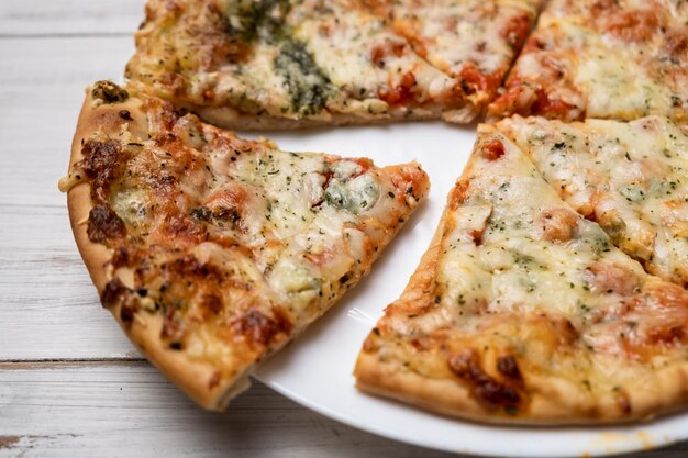 Pizza en rodajas con queso azul en un plato blanco Pedazos de pizza recién cocinada