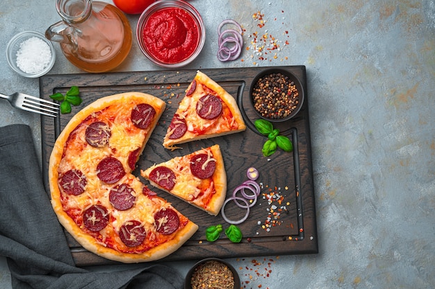 Pizza en rodajas sobre una tabla para cortar