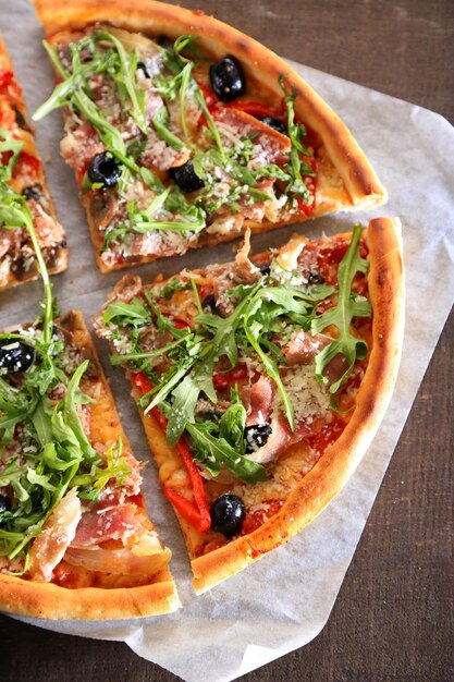 Pizza con rúcula sobre fondo de madera de color