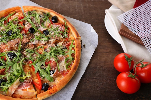 Pizza con rúcula sobre fondo de madera de color