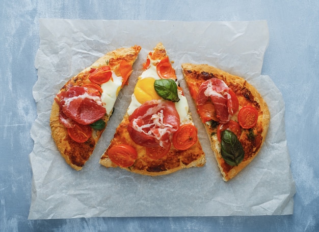 Pizza saborosa caseira com ovo, queijo, tomate e manjericão.