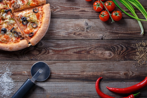 Pizza saborosa com ingredientes em uma placa de madeira. Vista superior com espaço vazio no centro