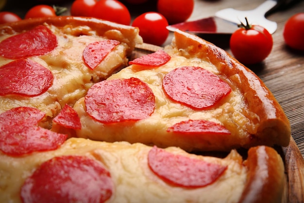 Pizza saborosa quente com salame em fundo de madeira close-up