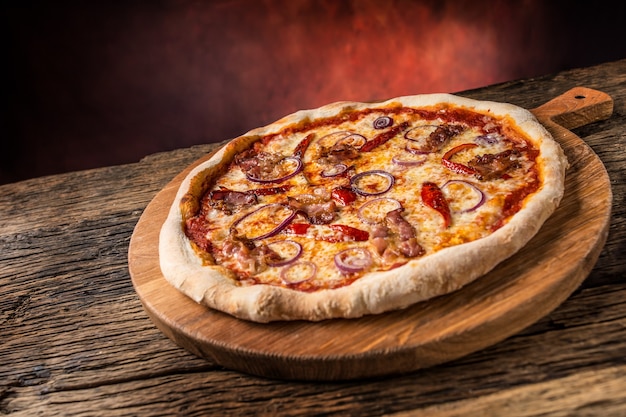 Pizza. Sabrosa pizza italiana fresca con tocino cihili pepper y cebolla servida en mesa de madera vieja.