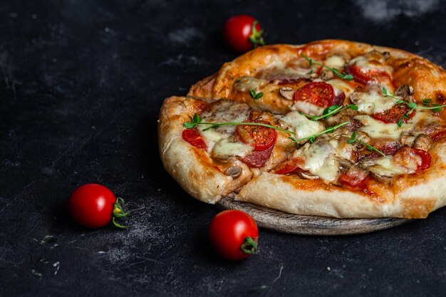 Pizza con salami y champiñones sobre un fondo oscuro