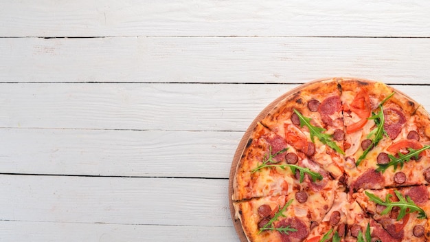 Pizza con salami de salchicha y mozzarella Vista superior Sobre un fondo de madera Espacio de copia