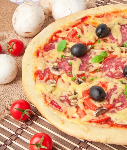 pizza con salami, tomates y champiñones