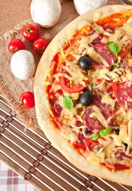 pizza con salami, tomates y champiñones