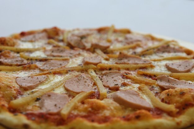 Pizza con salchichas pepino pimienta queso cebolla aislado sobre fondo blanco de madera Anuncio para la red social de restaurantes caffee Promoción para pizzería