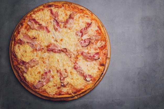 Pizza con salchichas sobre fondo de piedra negra