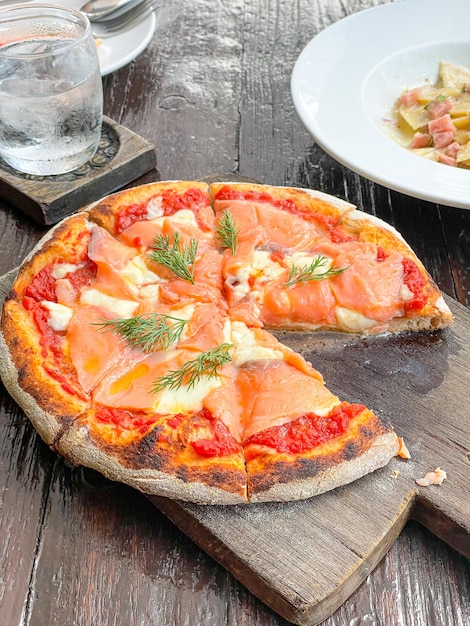 pizza de salmón ahumado en bandeja de madera