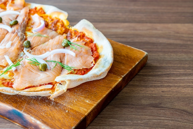 pizza de salmón ahumado en tablero de madera