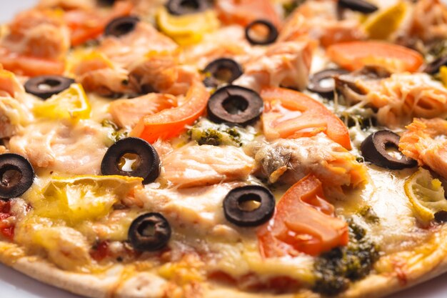 Pizza con salmón, tomates y aceitunas. Vista cercana