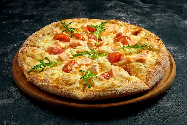 Pizza con salmón, tomates y rúcula sobre un fondo de piedra negra. ángulo de visión de 45 grados. primer plano, enfoque selectivo