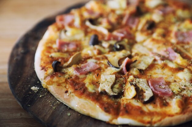 Pizza schinken und pilz auf holz hintergrund