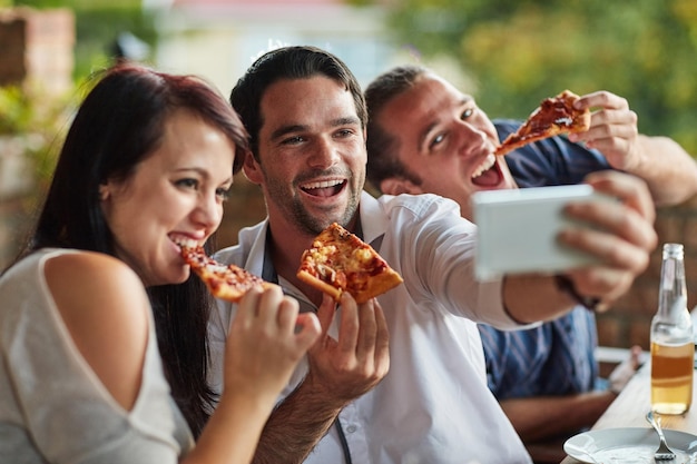 Pizza selfie e sorriso com amigos no restaurante juntos para vincular fome ou reunião social Comer fast food e memória com um grupo de pessoas felizes em um café para uma refeição ou foto de perfil
