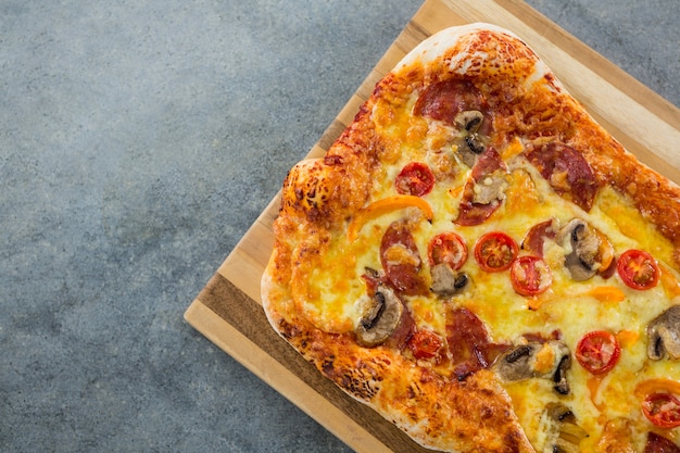 Pizza servida em uma tábua sobre uma prancha de madeira
