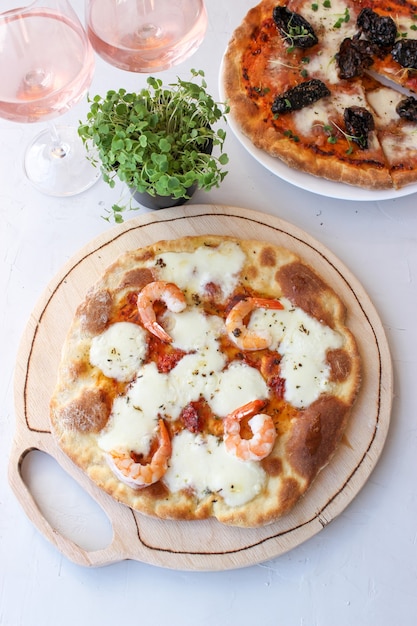 Pizza en una tabla de madera con mozzarella, mini rúcula.