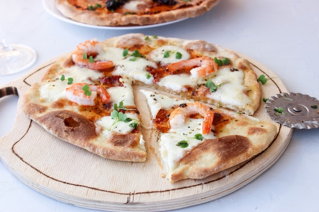 Pizza en una tabla de madera con mozzarella, mini rúcula.