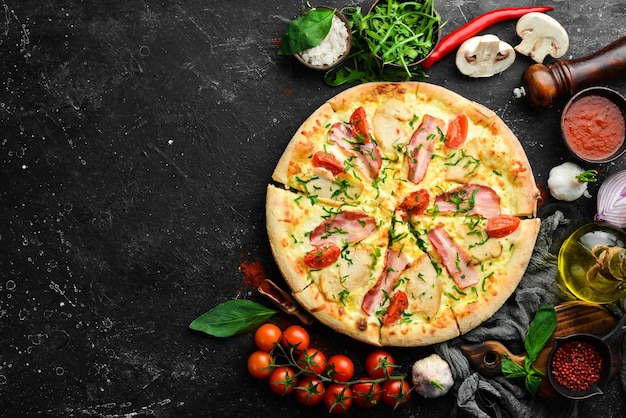 Pizza con tocino de pollo y tomates cherry Cocina italiana Sobre un fondo negro