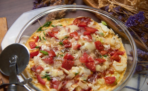 Una pizza con tomates y queso encima.