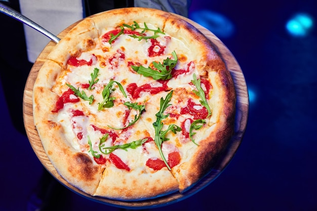 Pizza con tomates con queso y rúcula