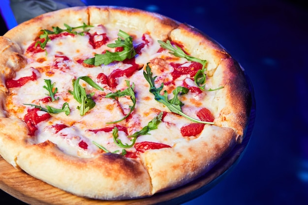 Pizza con tomates con queso y rúcula