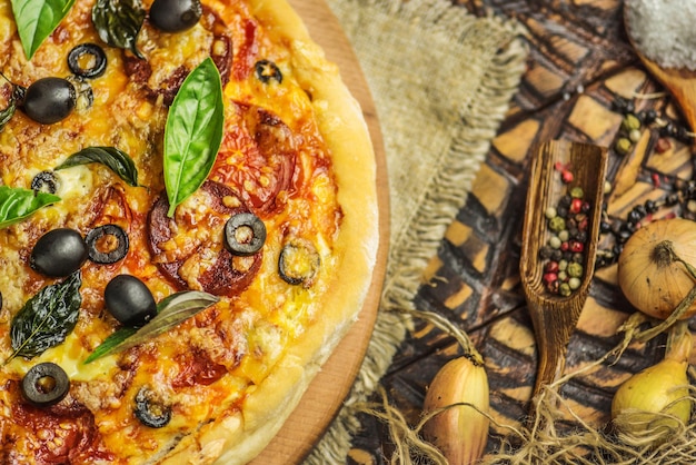 Pizza tradicional com queijo tomate azeitonas pretas manjericão