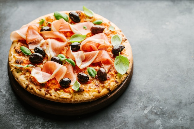 Pizza tradicional italiana en la mesa oscura