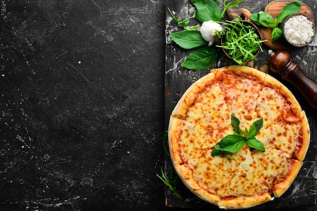 Pizza tradicional con queso y salsa de tomate Sobre un fondo de piedra negra Espacio libre para texto