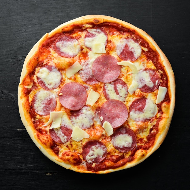Pizza tradicional con salchicha de salami y mozzarella Vista superior espacio libre para su texto Estilo rústico