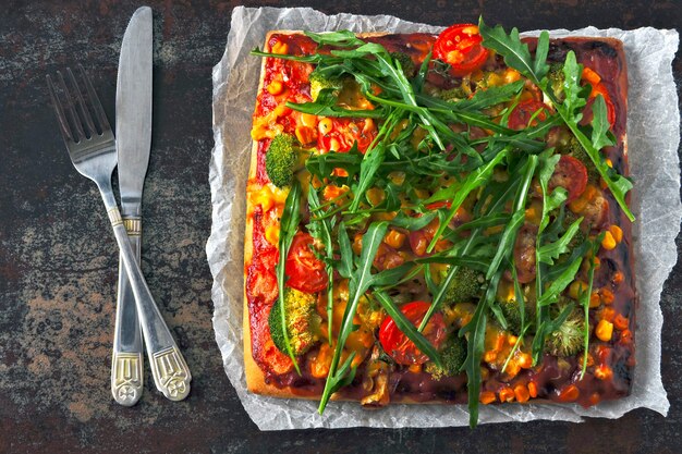 Pizza vegana con verduras y salsa.