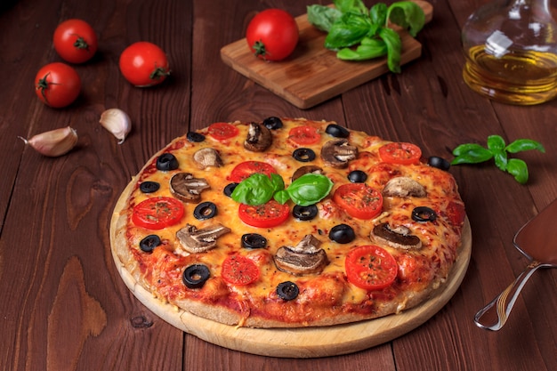 Pizza vegetariana com cogumelos, tomate cereja, azeitonas pretas e manjericão