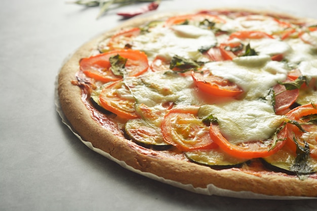 Pizza vegetariana feita com massa integral, com abobrinha, tomate e mussarela.
