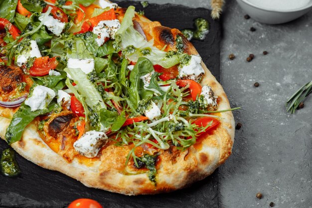 Pizza vegetariana con queso, tomates y verduras.