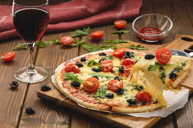 Pizza con vino tomates queso y rúcula