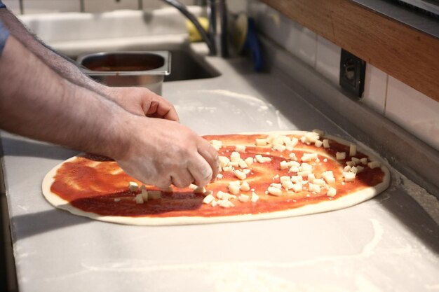 Pizzabäcker legte Soße in einer Großküche auf den Boden