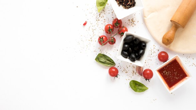 Foto pizzabestandteil mit dem pizzabrot und nudelholz vorbei lokalisiert auf weißem hintergrund