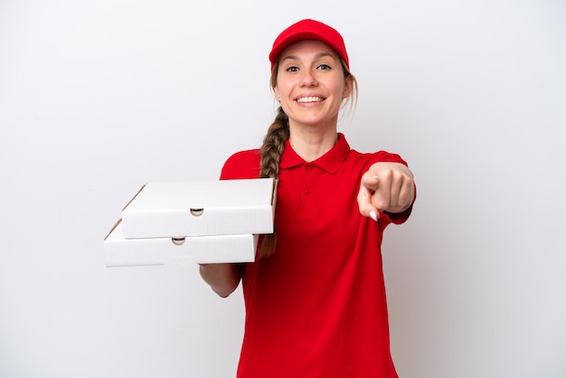 Pizzabotin mit Arbeitsuniform, die Pizzakartons isoliert auf weißem Hintergrund aufhebt und mit fröhlichem Gesichtsausdruck nach vorne zeigt
