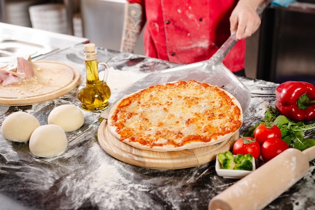 Pizzaiolo prepara pizza en la cocina el chef prepara la masa