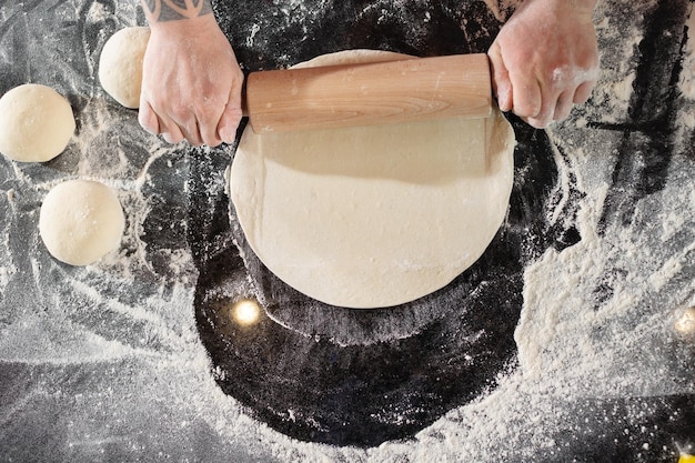 Pizzaiolo prepara pizza en la cocina el chef prepara la masa