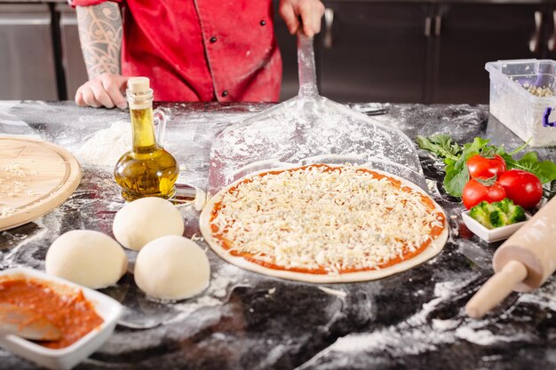 Pizzaiolo prepara pizza en la cocina el chef prepara la masa