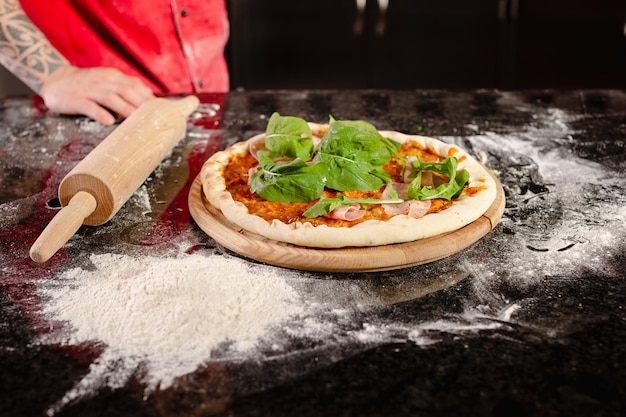 Pizzaiolo prepara pizza en la cocina el chef prepara la masa