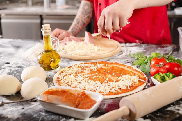 Pizzaiolo prepara pizza en la cocina el chef prepara la masa